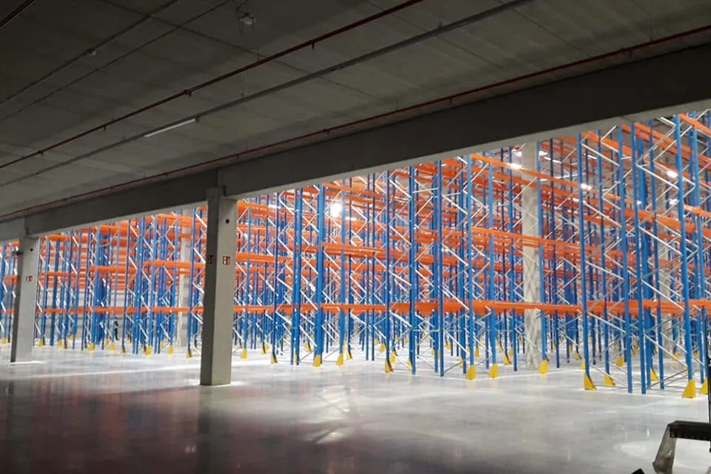 Magazijnhal met rijen blauwe en oranje palletstellingen