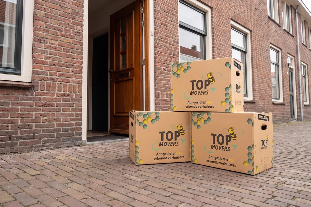 Top Movers-verhuisdozen bij de voordeur van een woning