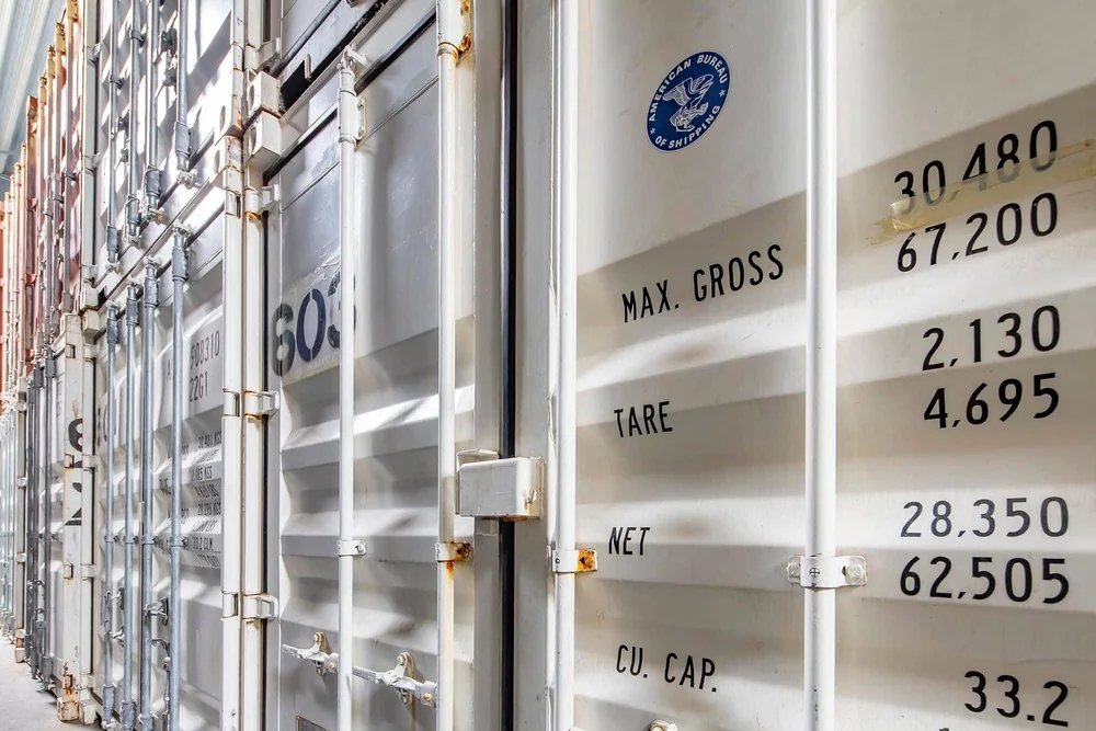 Opslagcontainers naast elkaar in de hal van De Bresser, met de gegevens op de deuren