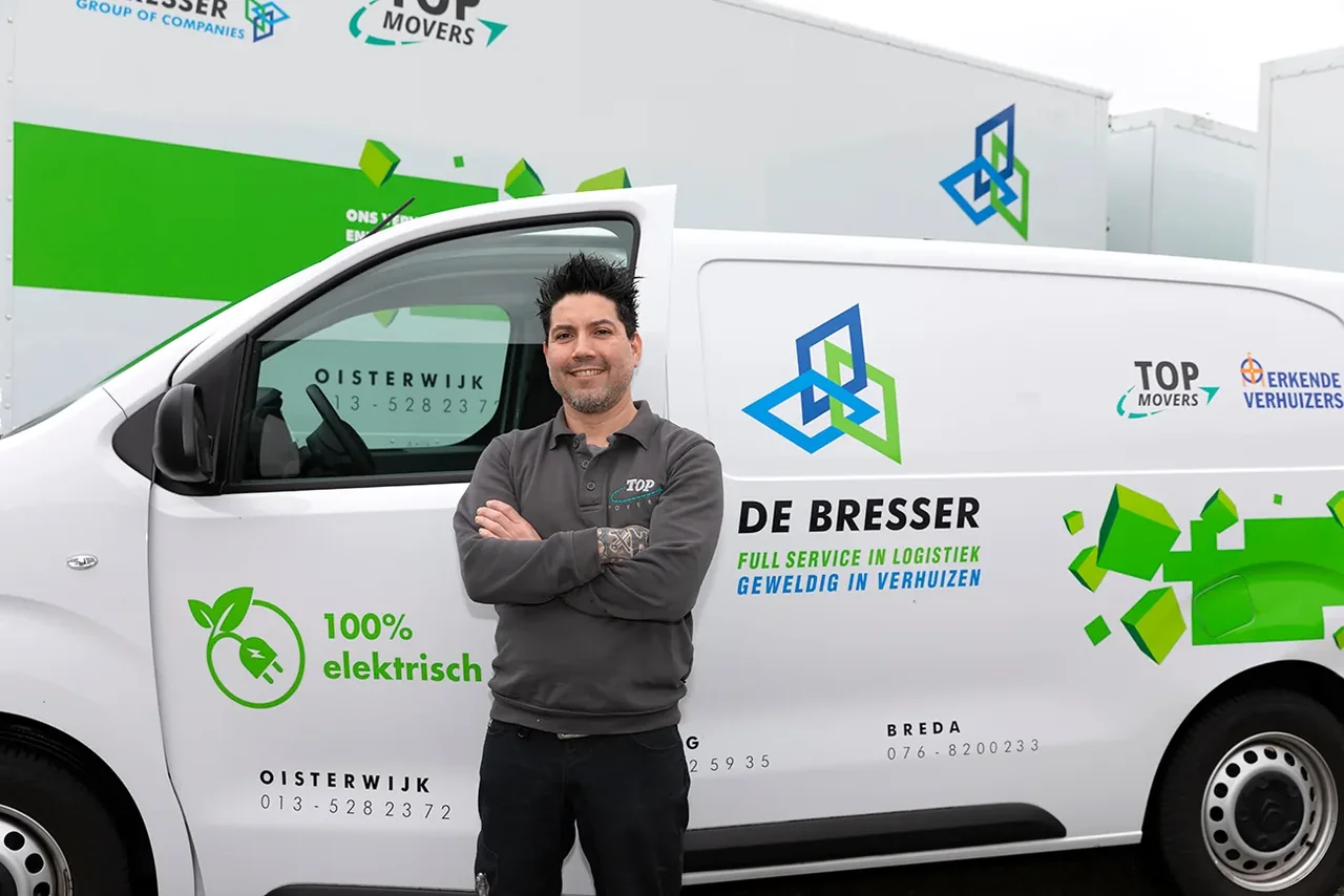 Medewerker van De Bresser met de armen over elkaar voor een elektrische bestelwagen van De Bresser
