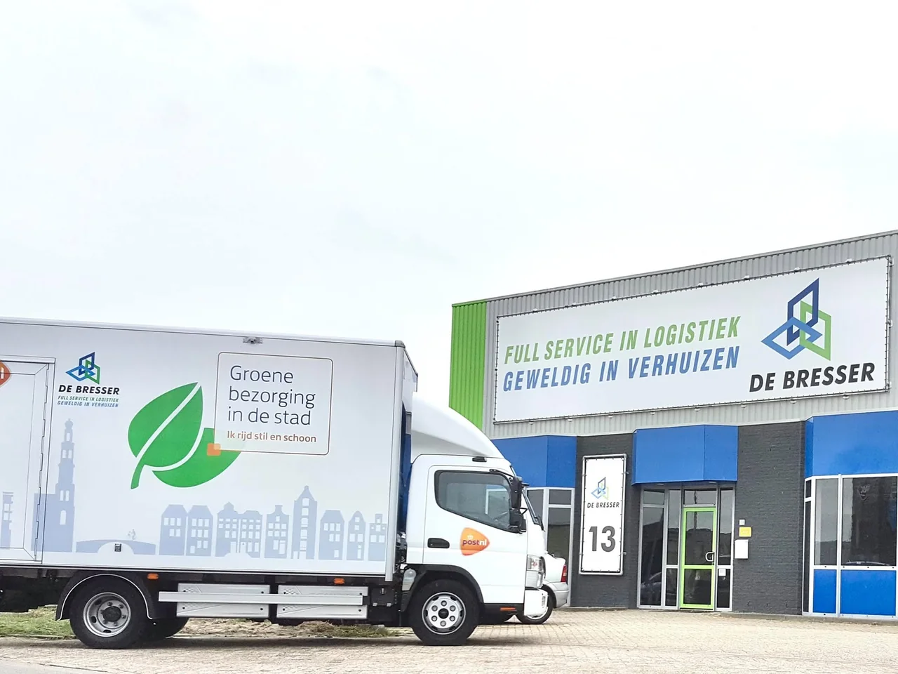 Elektrische vrachtwagen met De Bresser en PostNL op de opbouw voor het bedrijfspand van De Bresser